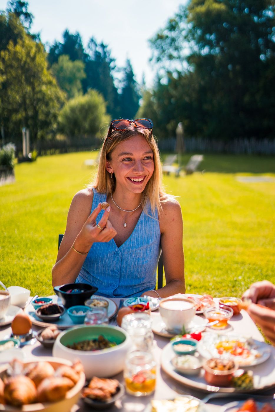 Julia lachend beim Frühstück im Garten